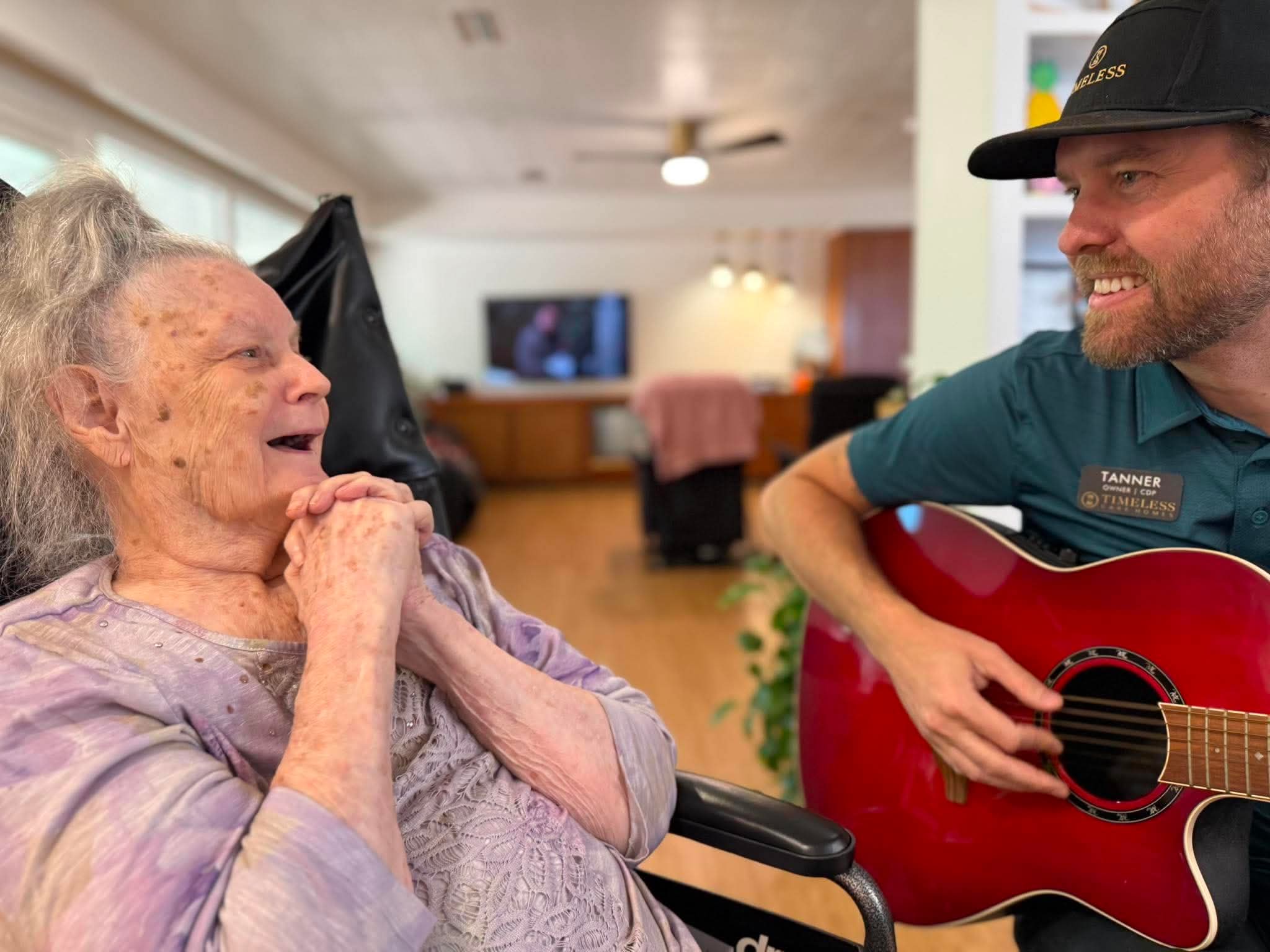 Tanner playing guitar for a resident at Timeless Care Homes